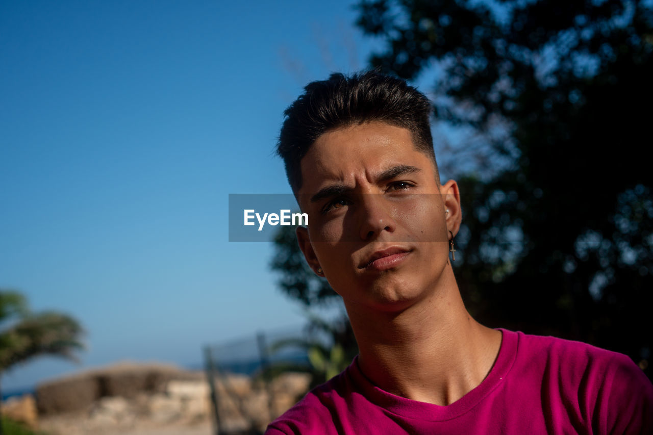 Cheerful ethnic guy standing in beach