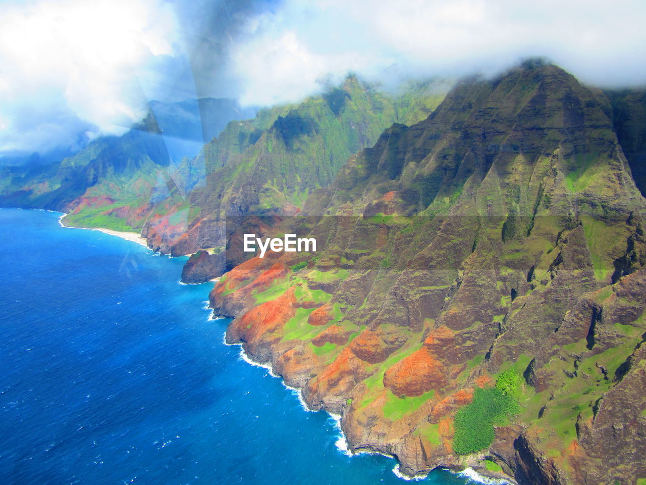 AERIAL VIEW OF SEA AND MOUNTAINS AGAINST SKY