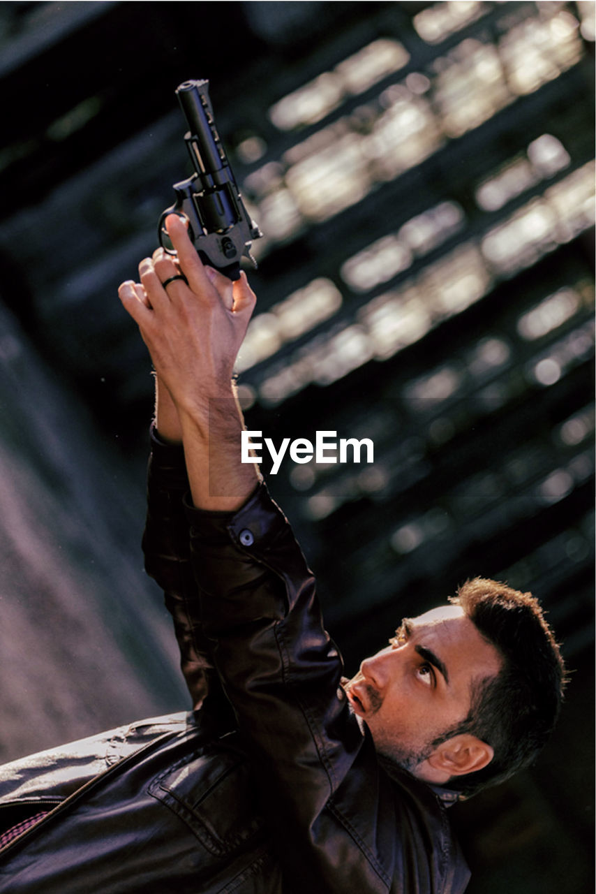 Tilt image of man aiming handgun