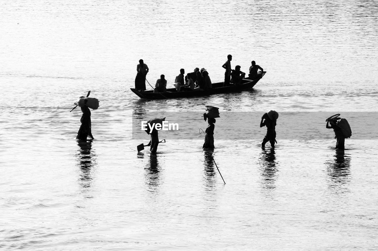 Silhouette people in river