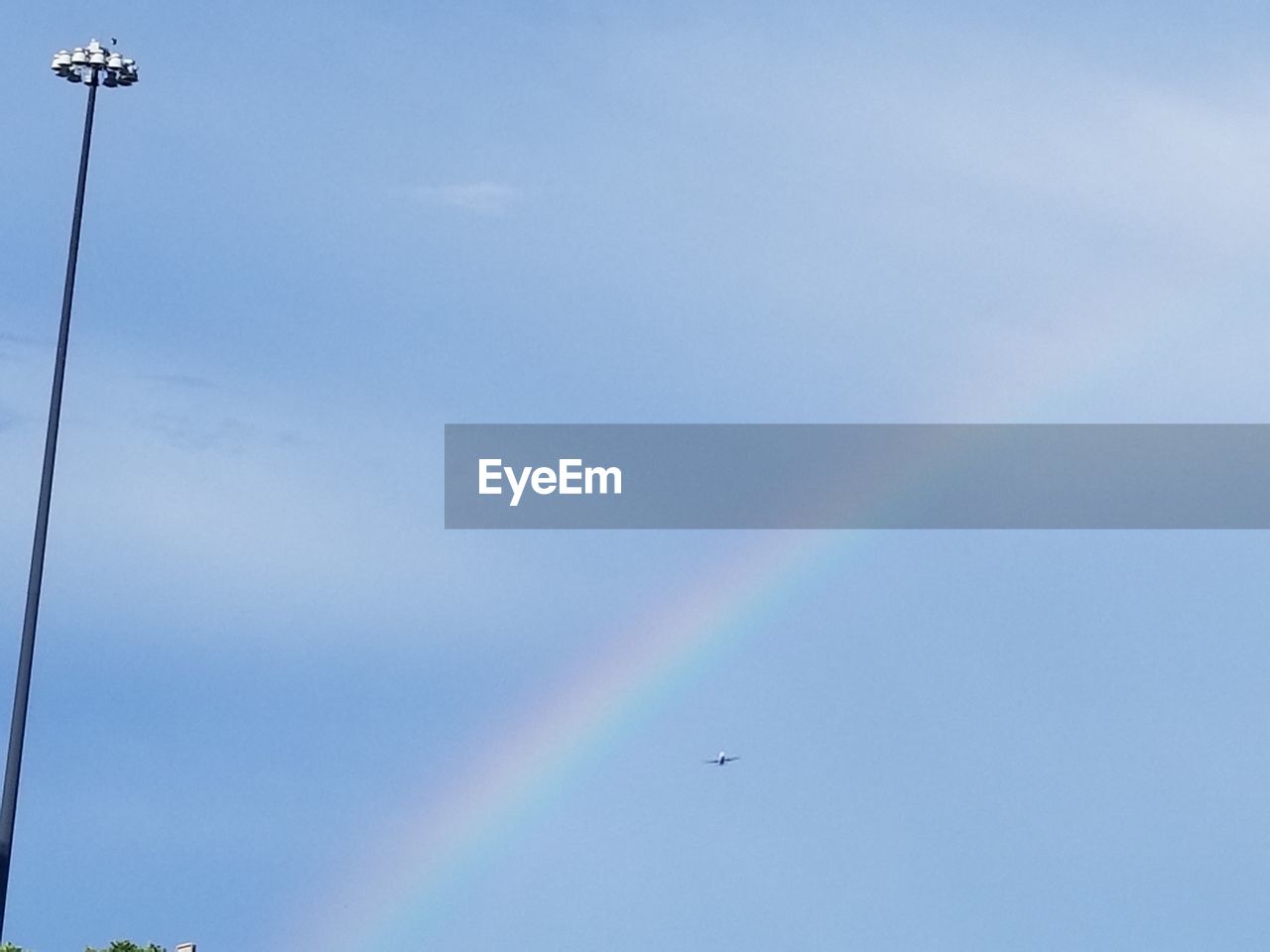 LOW ANGLE VIEW OF RAINBOW AGAINST BLUE SKY