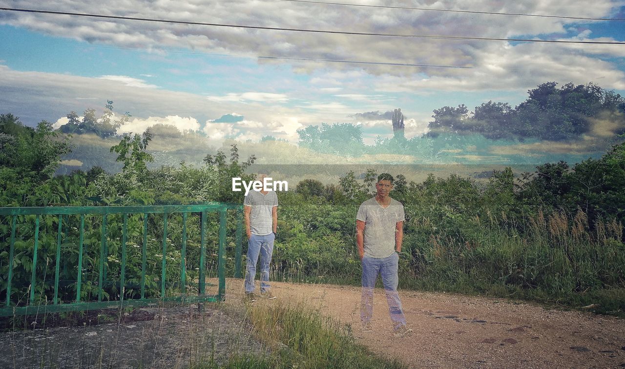 PANORAMIC SHOT OF FRIENDS STANDING AGAINST SKY