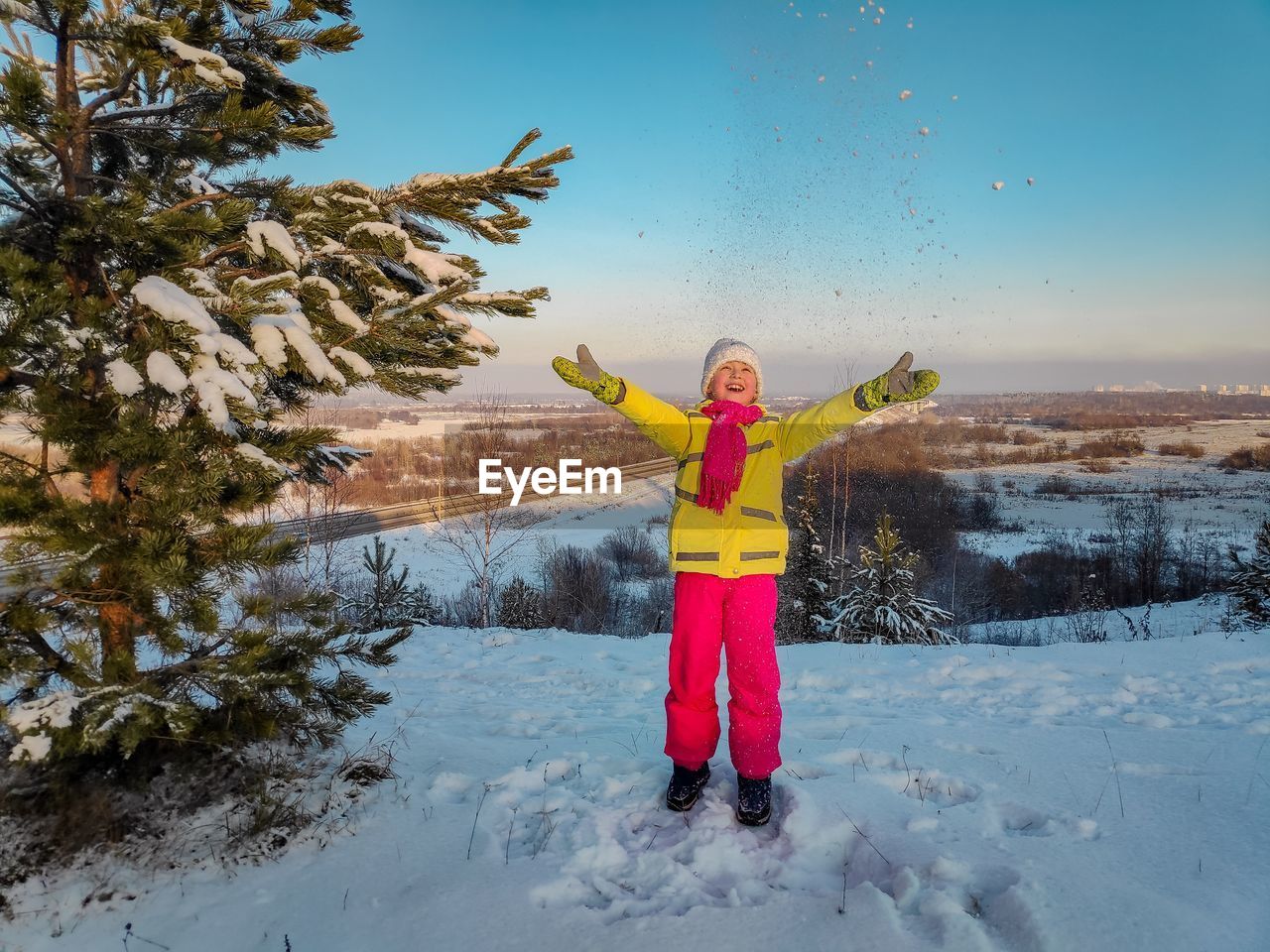 Full length of child standing on snow covered landscape during winter