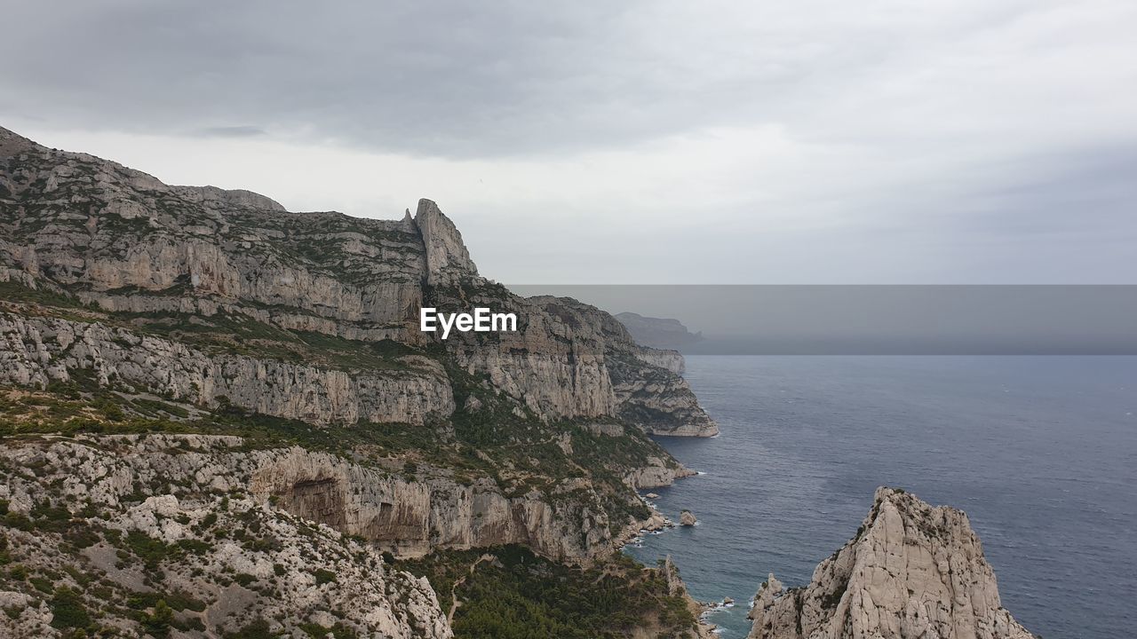 SCENIC VIEW OF SEA AND ROCKS AGAINST SKY