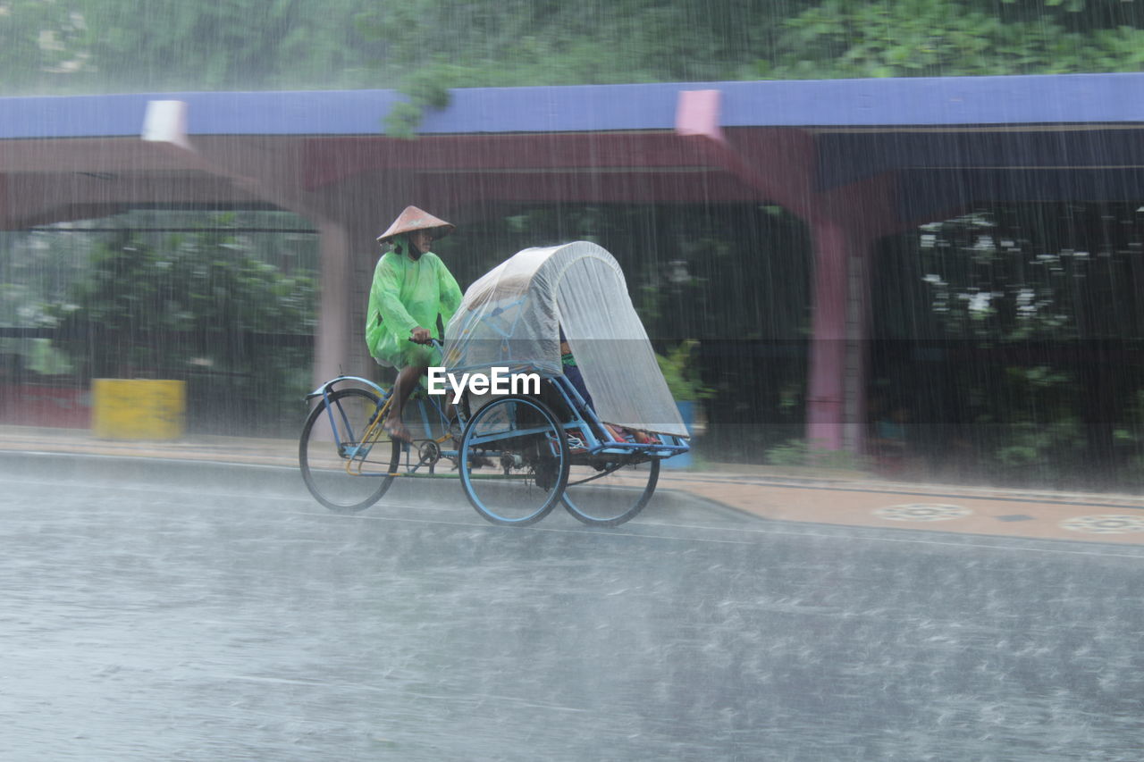 Rear view of man riding bicycle on street