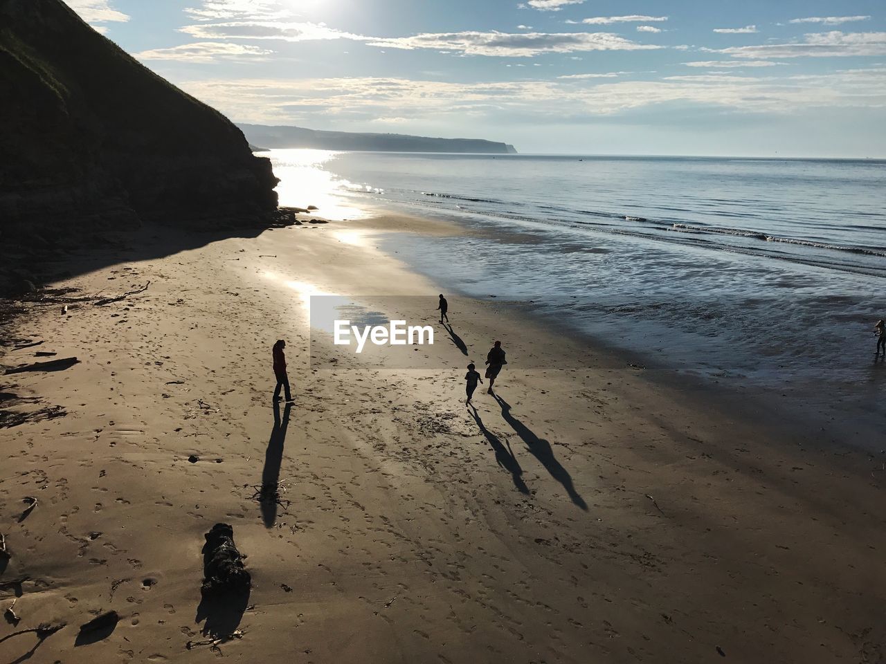 High angle view of people at beach against sky during sunset