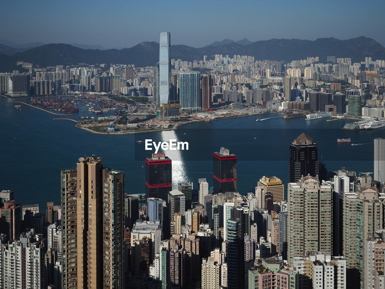 Aerial view of city by sea and buildings against sky