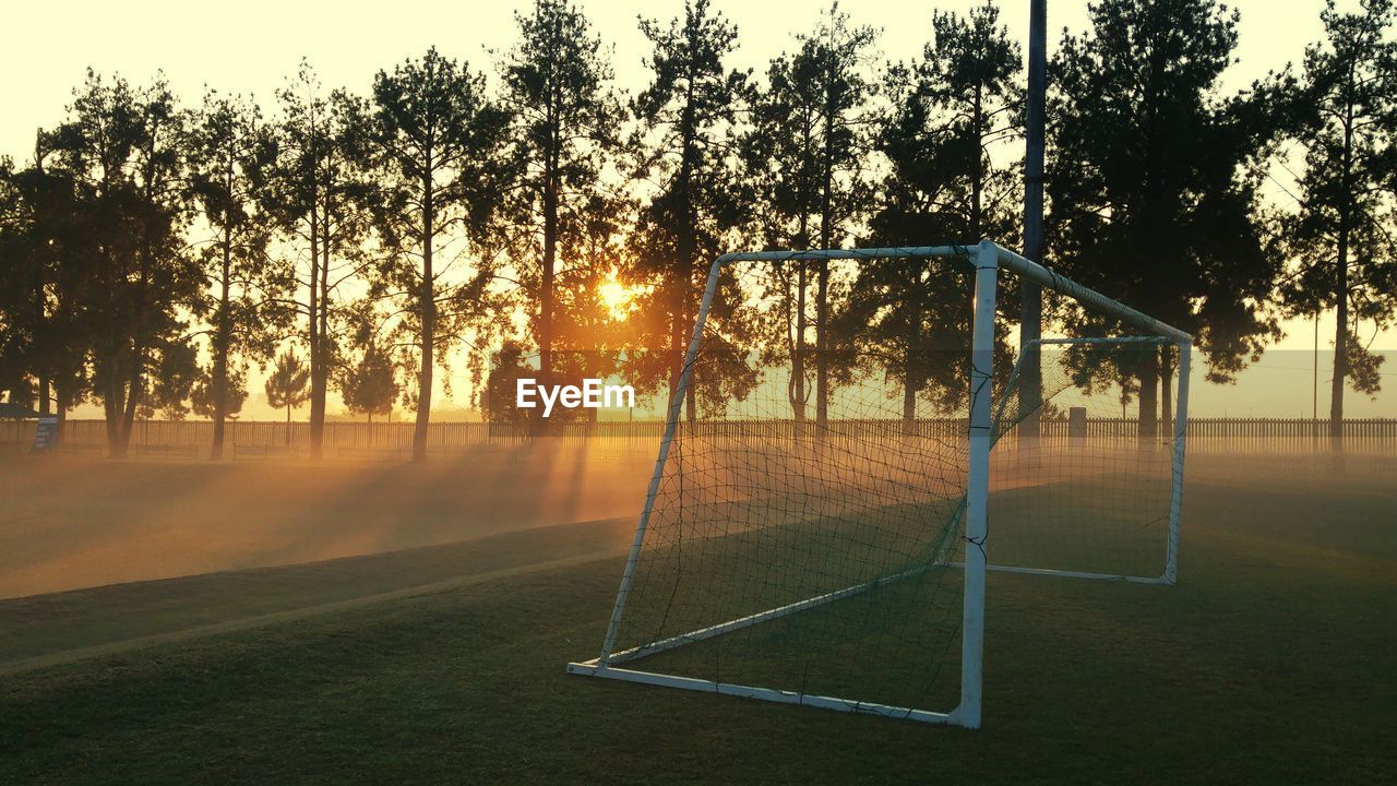 Goal post on soccer field during sunrise