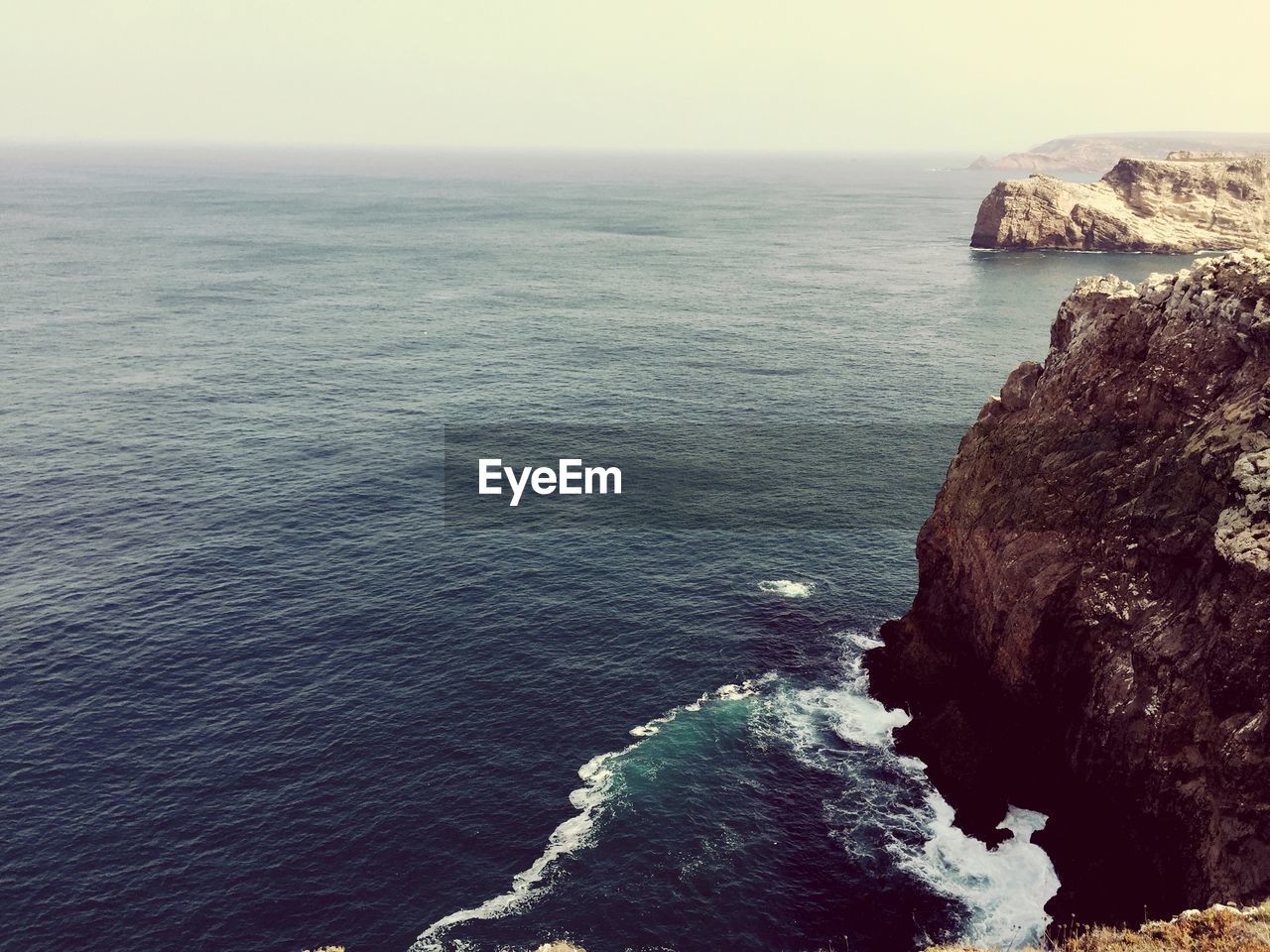 Rock formation by sea against sky