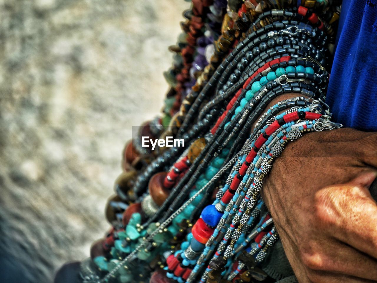 Cropped hand of man holding bead necklaces