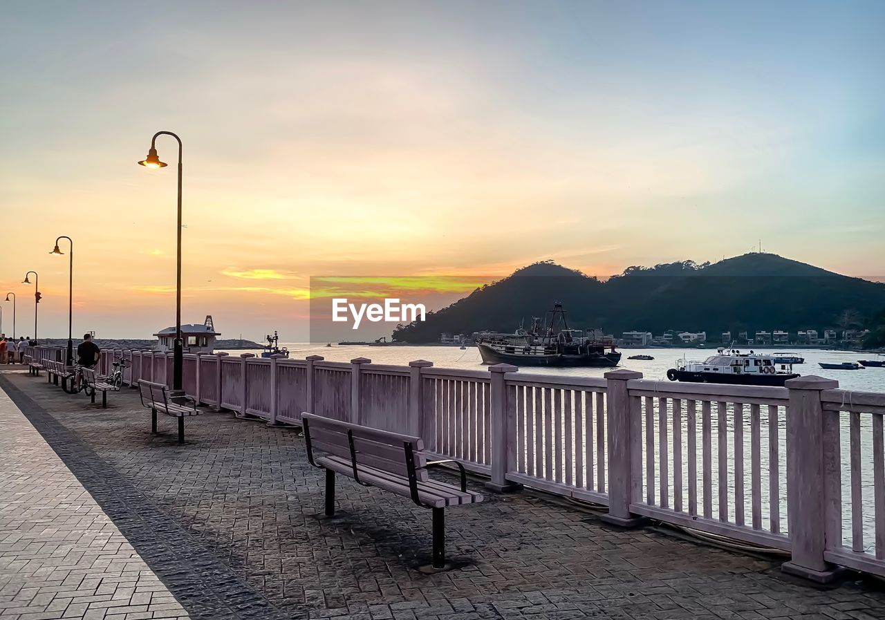 STREET BY PIER AGAINST SKY DURING SUNSET