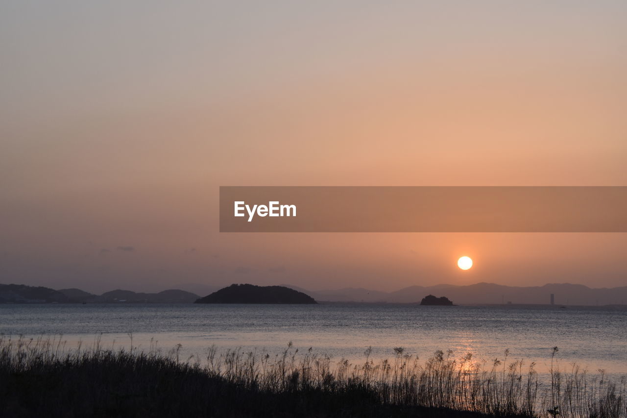 SCENIC VIEW OF SEA AGAINST ORANGE SKY DURING SUNSET