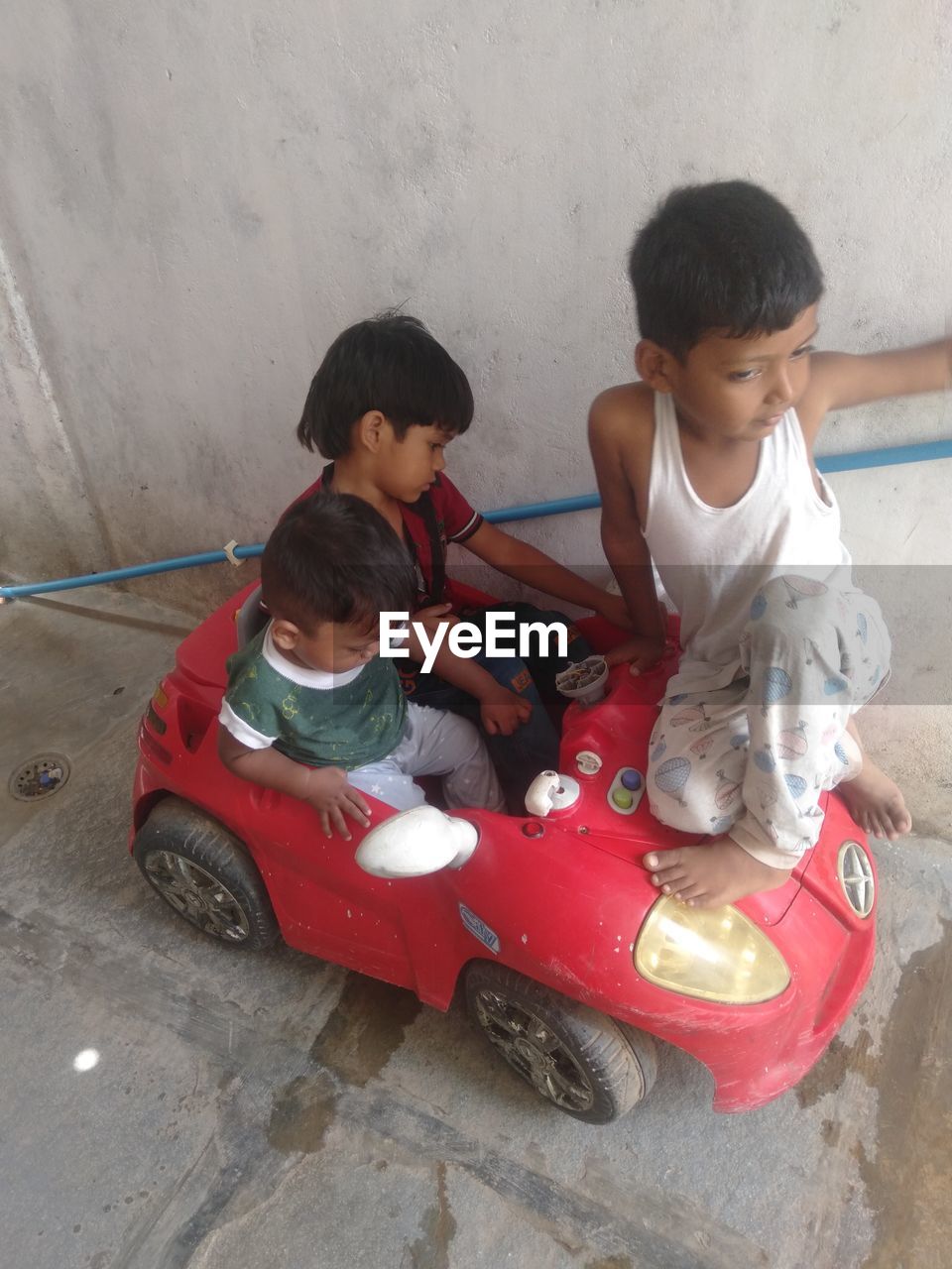 childhood, child, men, toddler, baby, togetherness, full length, two people, female, family, high angle view, sitting, person, vehicle, casual clothing, toy, women, red, bonding, friendship, car, leisure activity, transportation, happiness, emotion, lifestyles, day, toy car, fun, cute, positive emotion, human face, innocence, looking, land vehicle, adult, smiling, outdoors