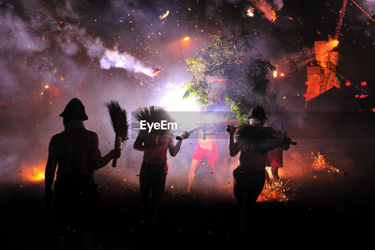 Silhouette of people against sky at night