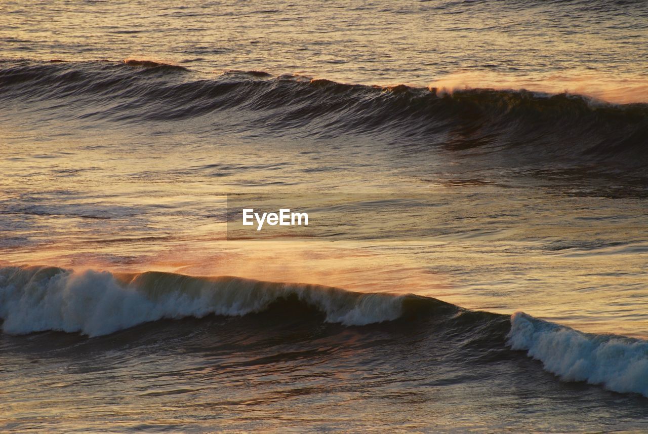 SCENIC VIEW OF SEA WAVES AGAINST SKY DURING SUNSET