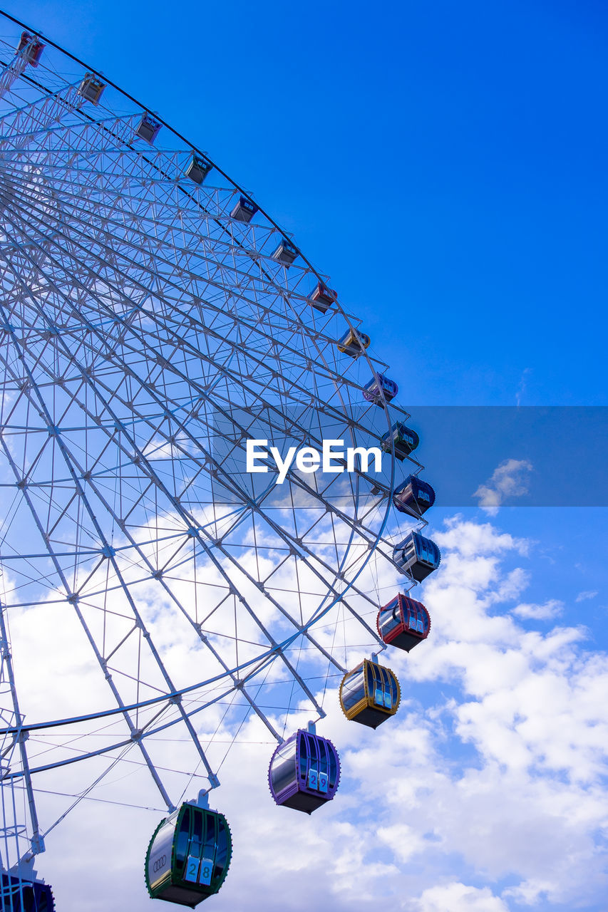 Low angle view of ferris wheel against blue sky