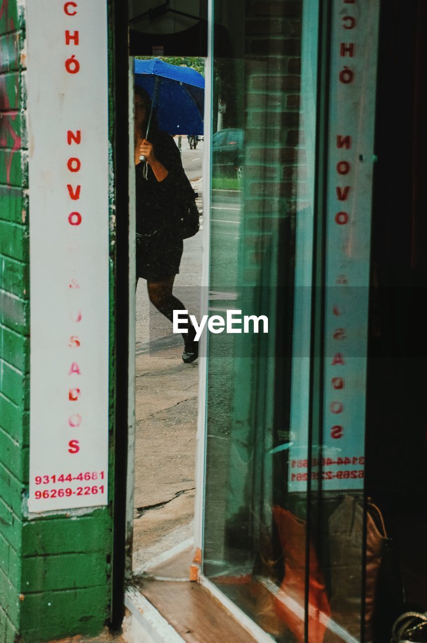 REFLECTION OF MAN IN GLASS WINDOW