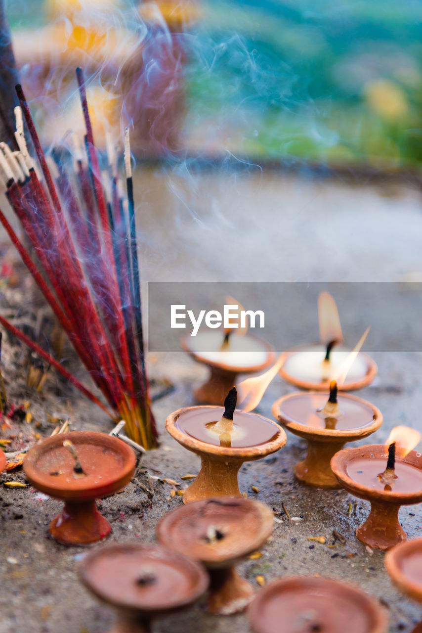 Close-up of lit oil lamps