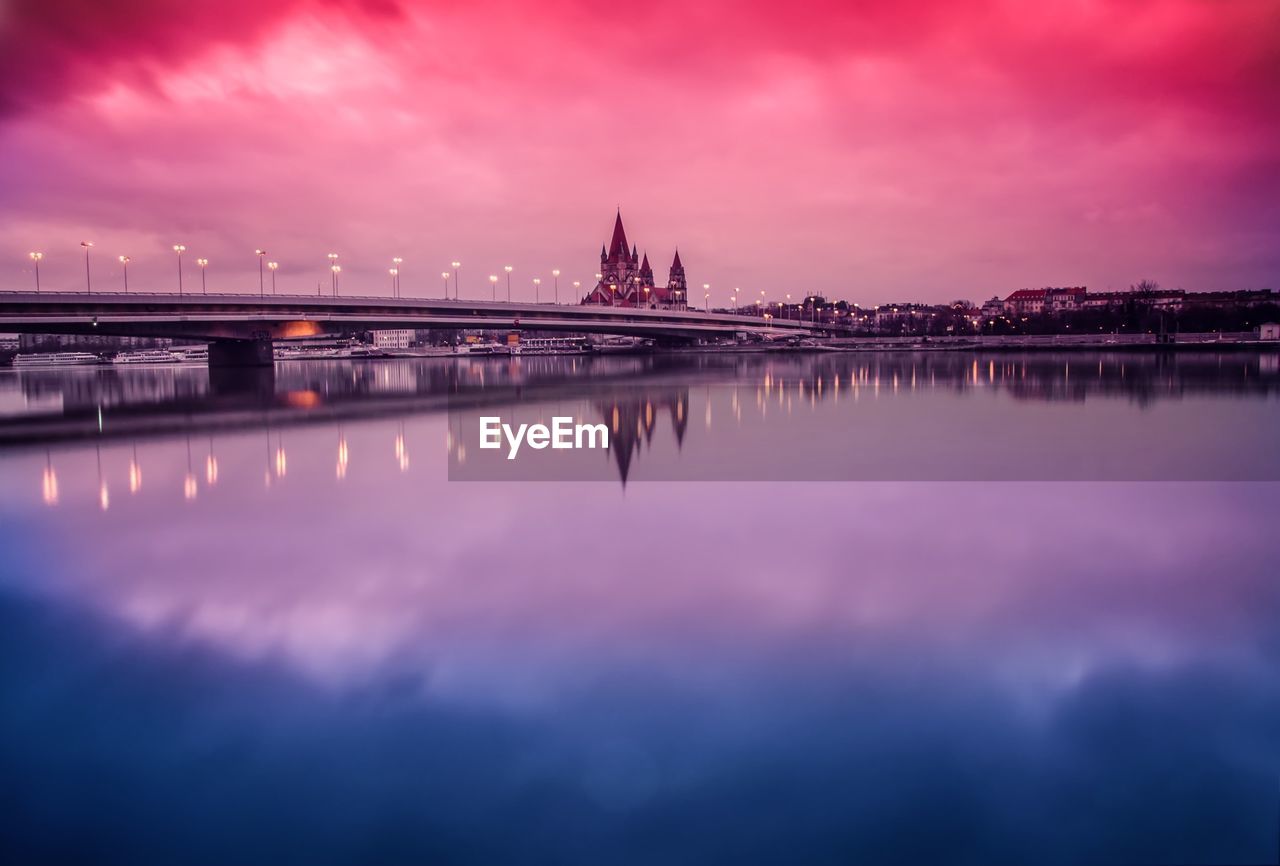 Reflection of cloudy sky on calm lake at dusk