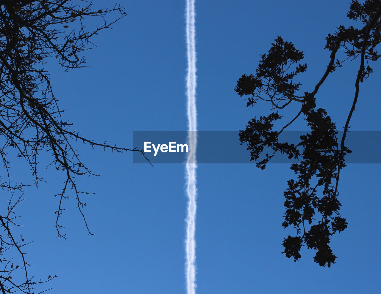 Low angle view of contrail at blue sky