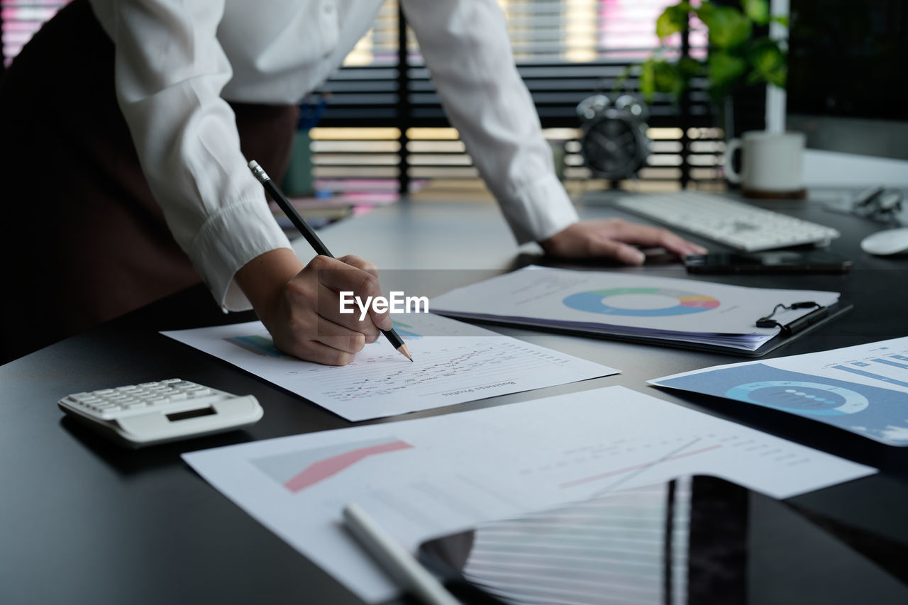 midsection of business people working at desk