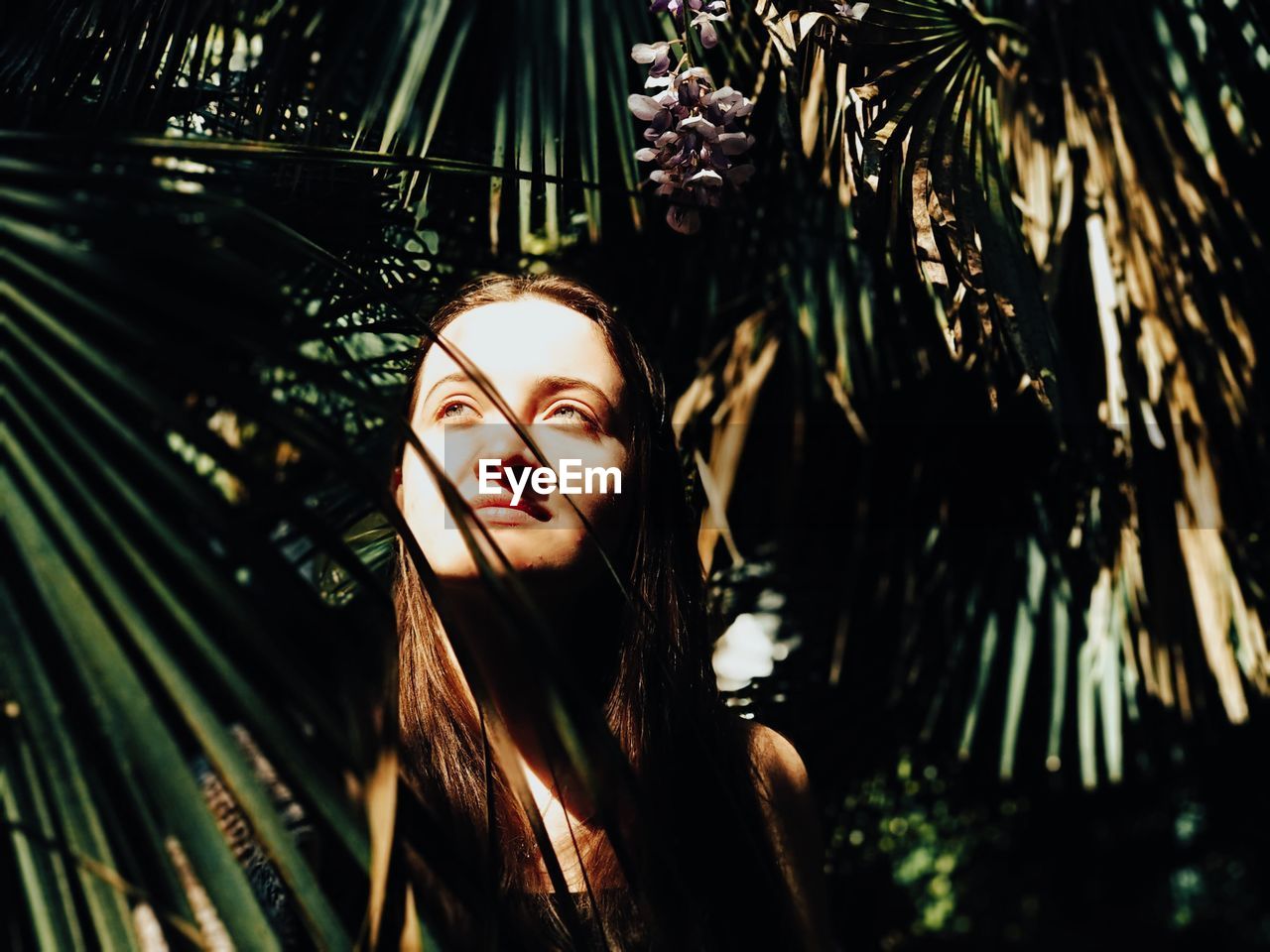 Portrait of young woman with palm tree