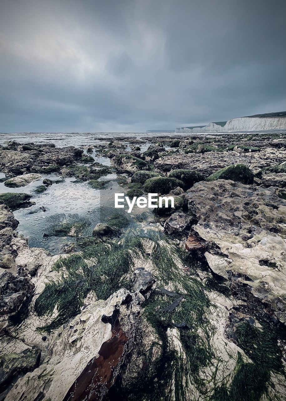 AERIAL VIEW OF ROCKS ON SHORE AGAINST SKY