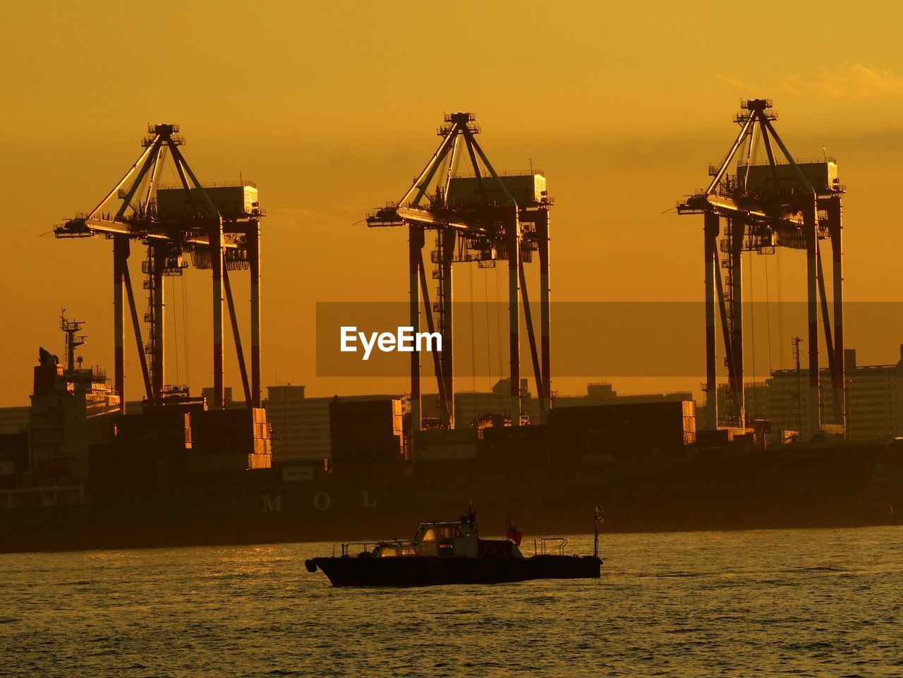 SILHOUETTE SHIP AT HARBOR AGAINST SKY AT SUNSET