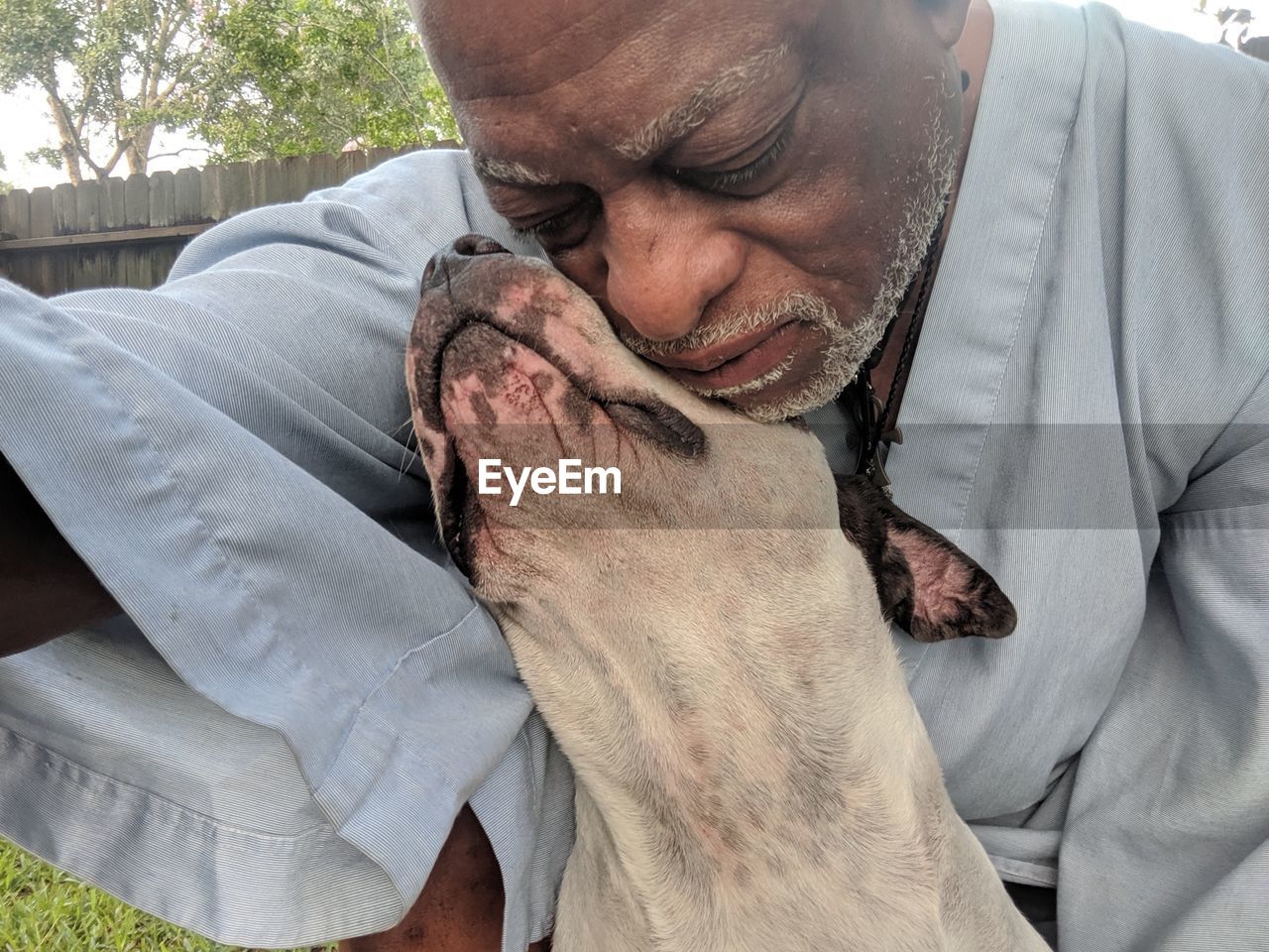 Close-up of man embracing dog