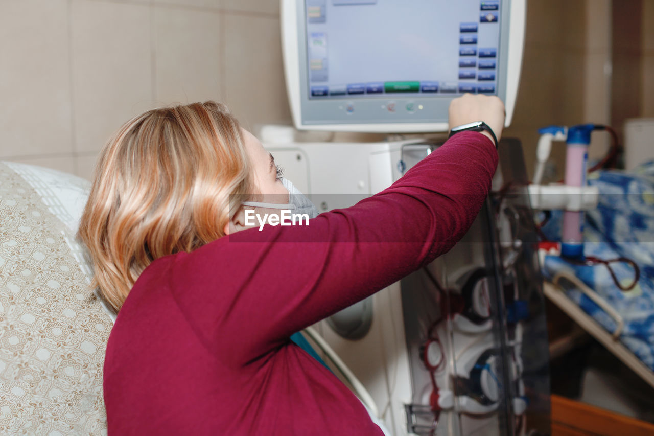 Young beautiful girl, monitored by dialysis system equipment during hemodialysis