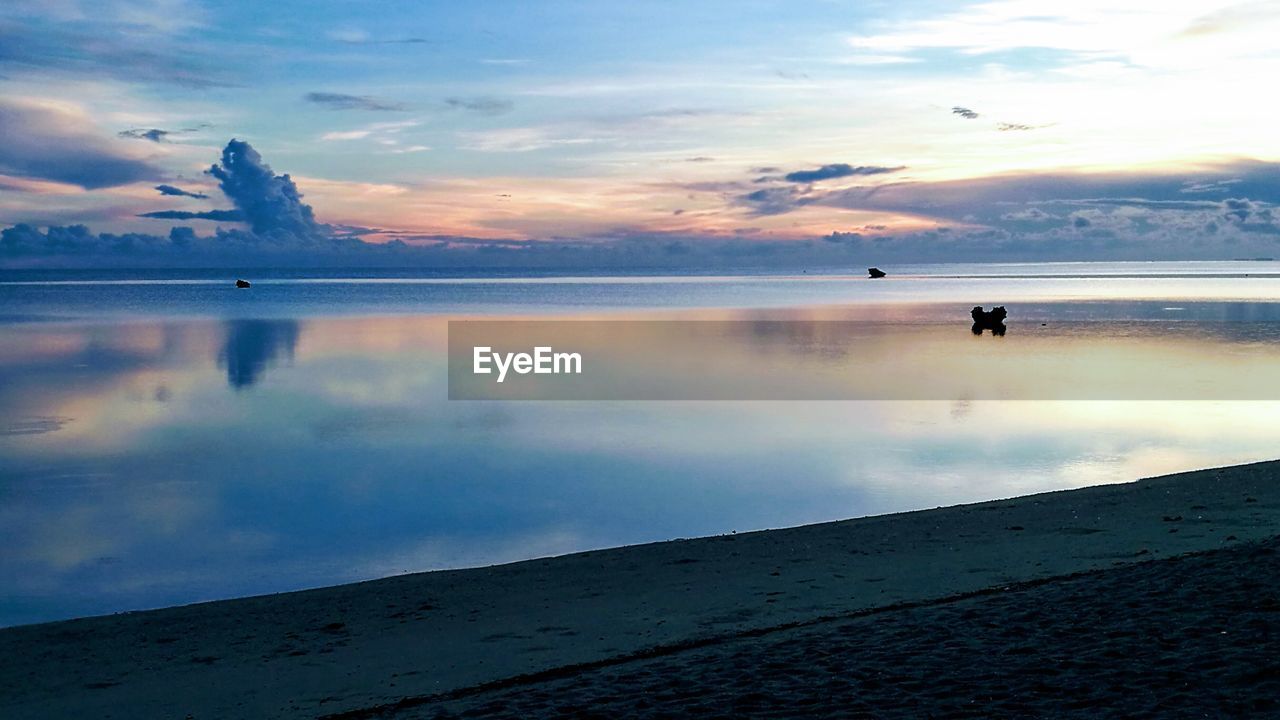 SCENIC VIEW OF BEACH AGAINST SKY DURING SUNSET