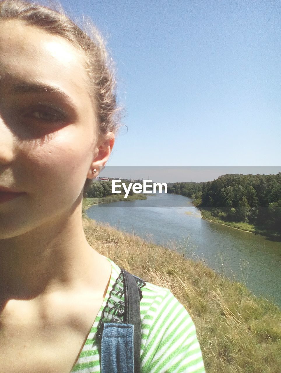 CLOSE-UP OF BEAUTIFUL YOUNG WOMAN AGAINST CLEAR SKY