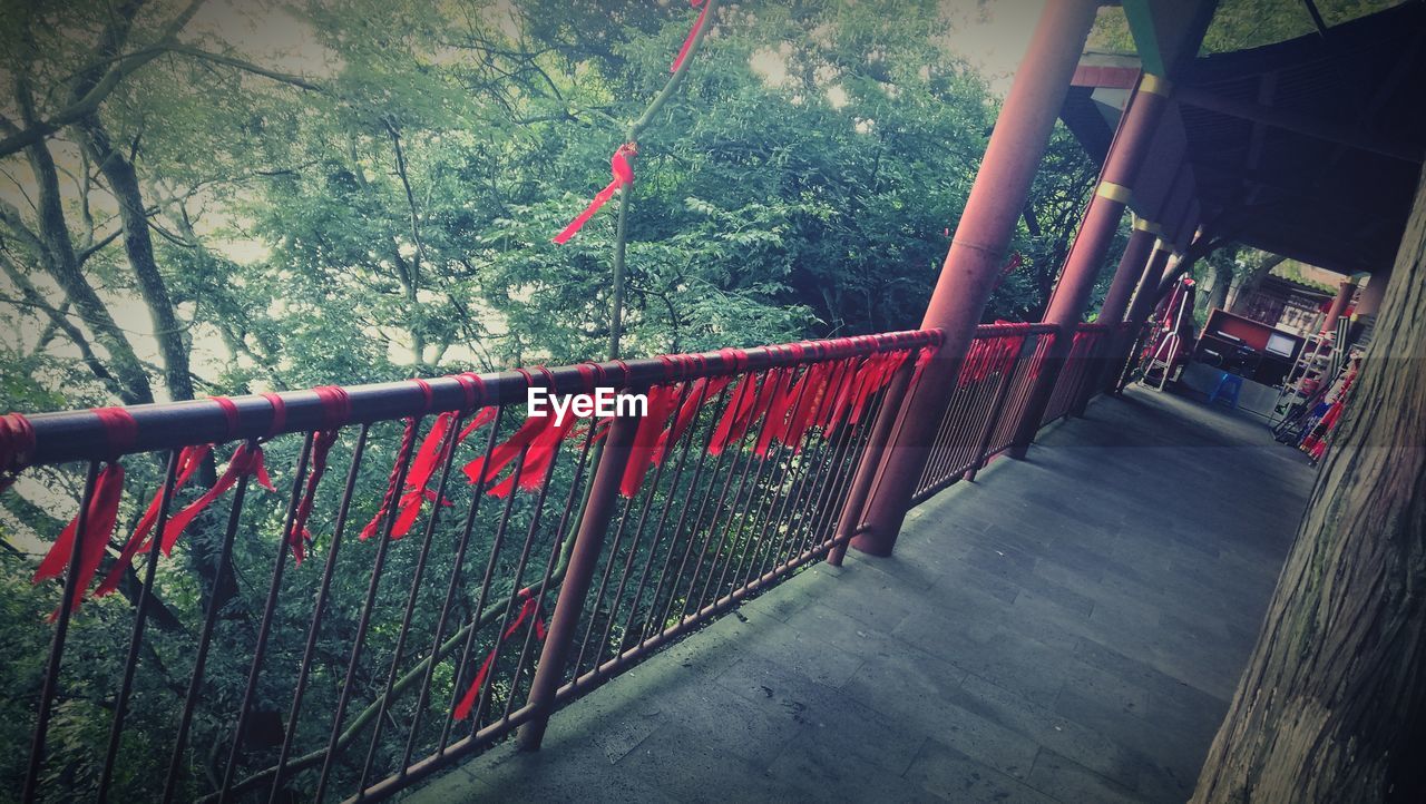 TILT IMAGE OF RAILING HANGING IN FOREST