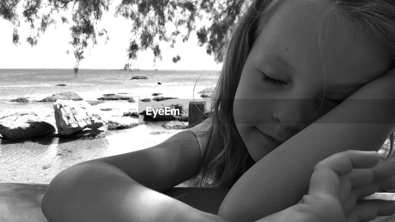 Close-up of cute girl sitting at beach