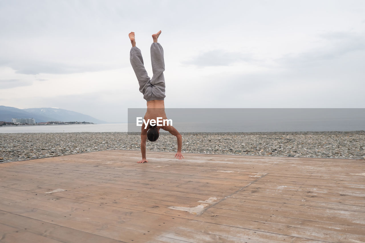 rear view of woman jumping at beach