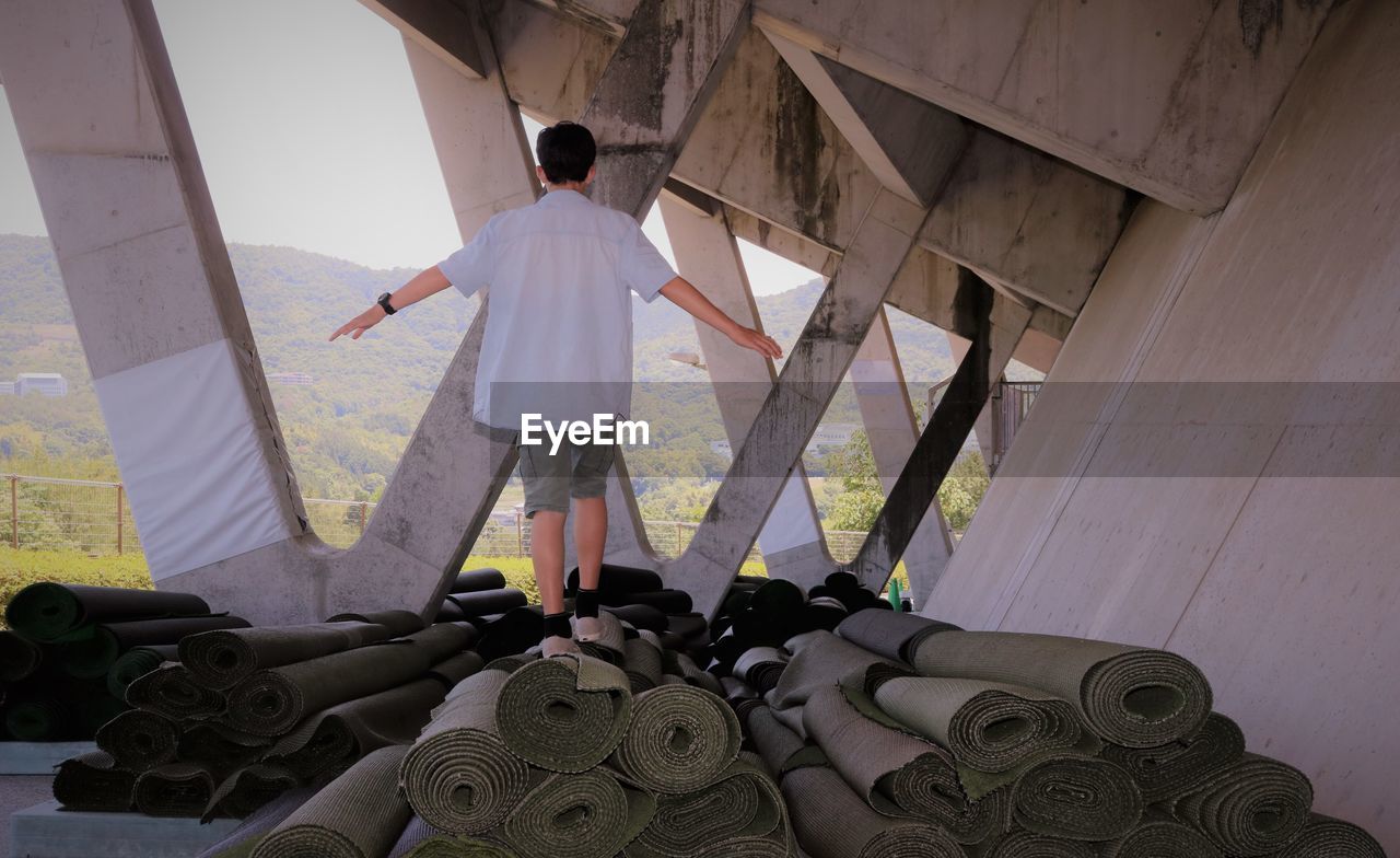 Rear view of man standing on matting under stadium