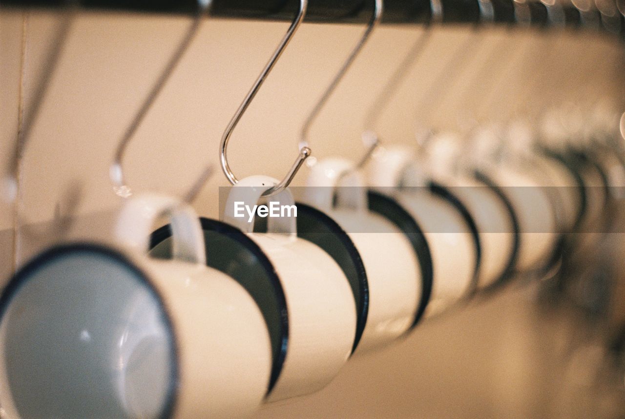 Close-up of cups hanging on metallic hook