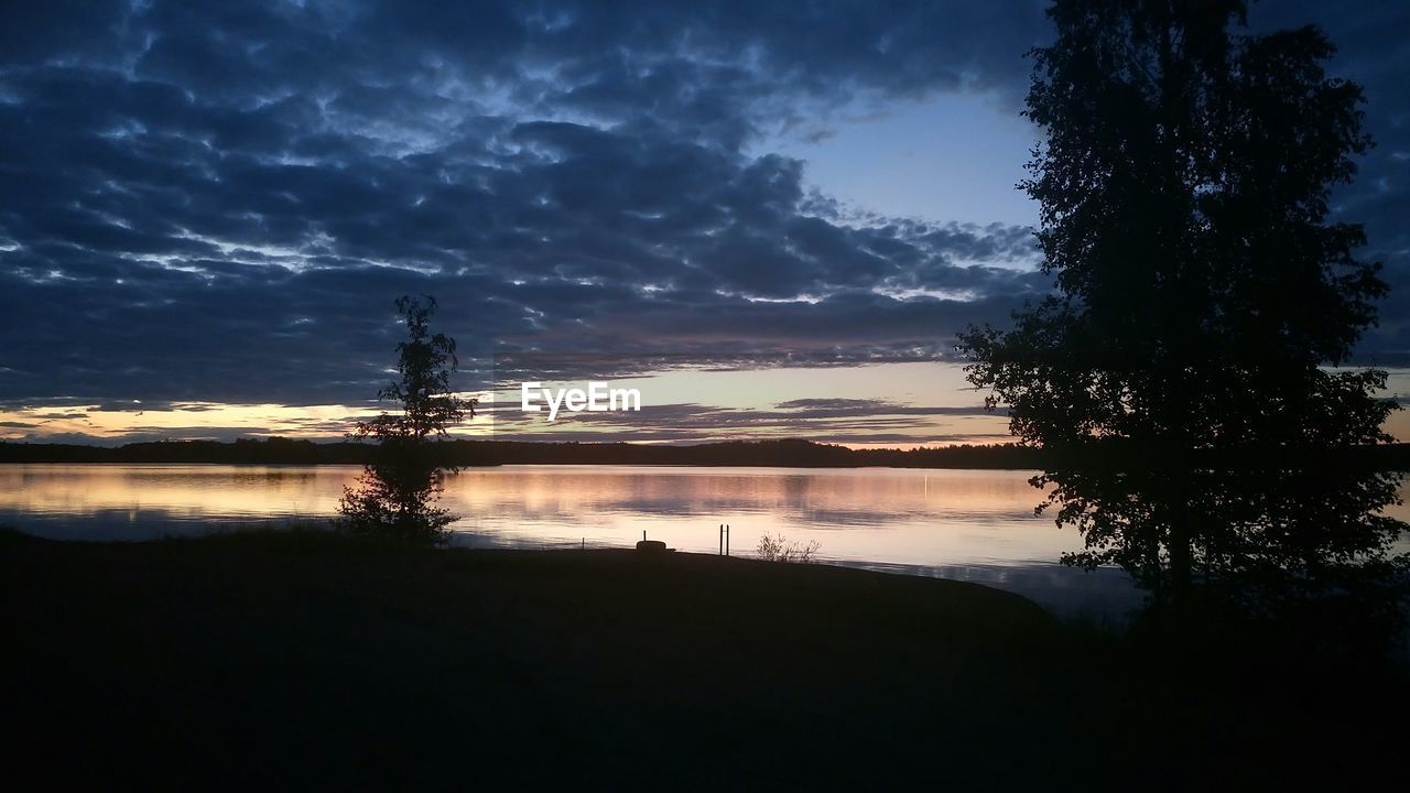 SILHOUETTE TREES BY LAKE AGAINST SKY AT SUNSET