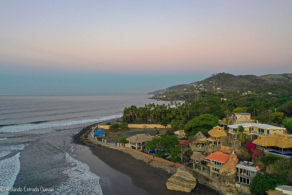 sea, water, coast, land, sky, architecture, beach, nature, building exterior, building, built structure, scenics - nature, shore, sunset, environment, city, travel destinations, beauty in nature, travel, landscape, body of water, ocean, vacation, bay, tourism, horizon, coastline, house, outdoors, high angle view, no people, horizon over water, clear sky, tranquility, holiday, residential district, terrain, trip, seascape, cityscape, dusk, tree, plant, summer, transportation, idyllic