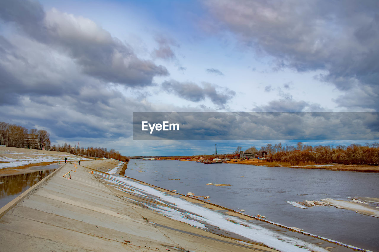 PANORAMIC VIEW OF ROAD BY RIVER AGAINST SKY