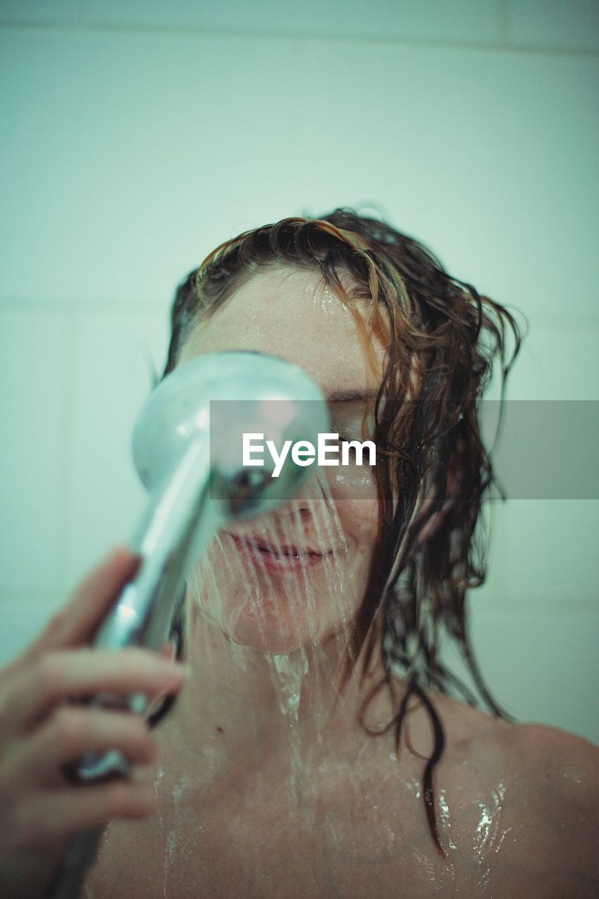 Woman taking shower in bathroom