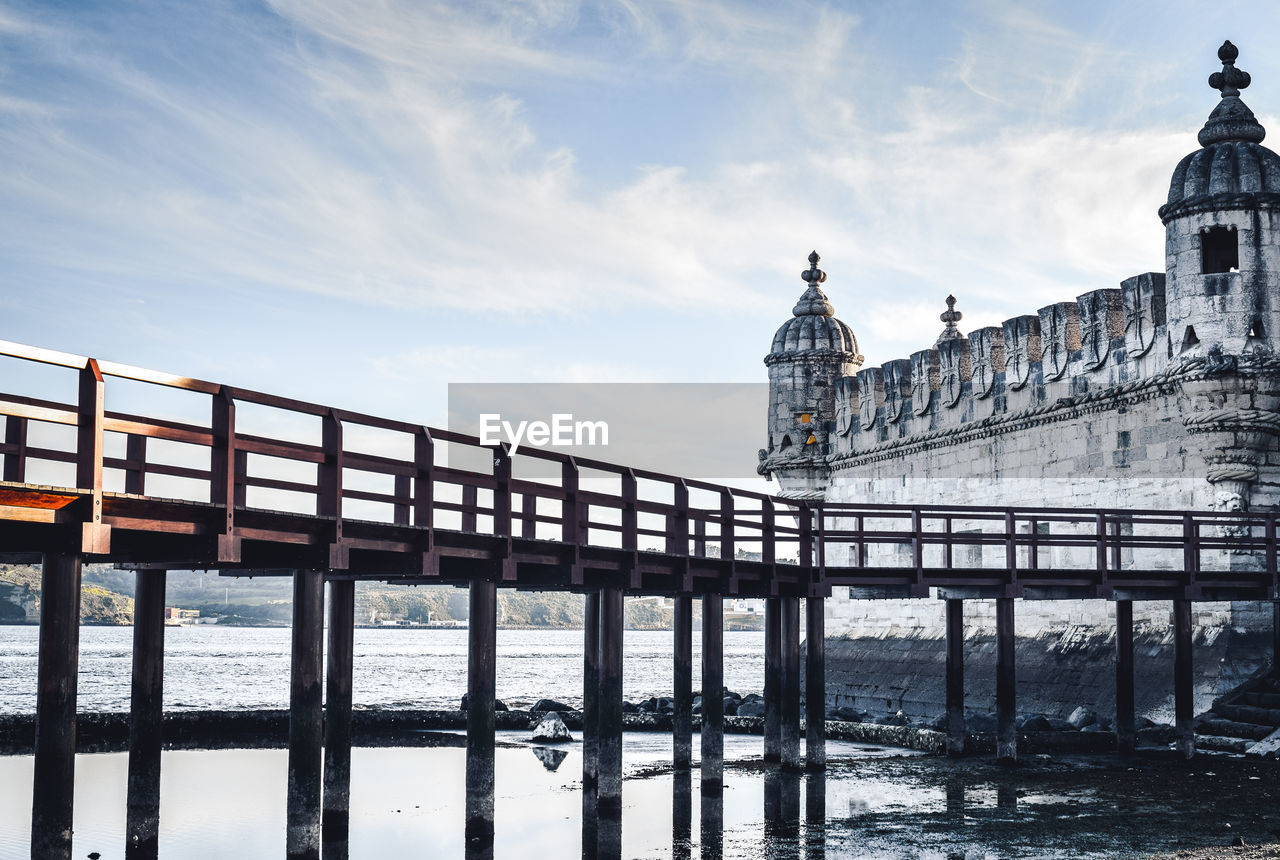 View of bridge over sea against cloudy sky