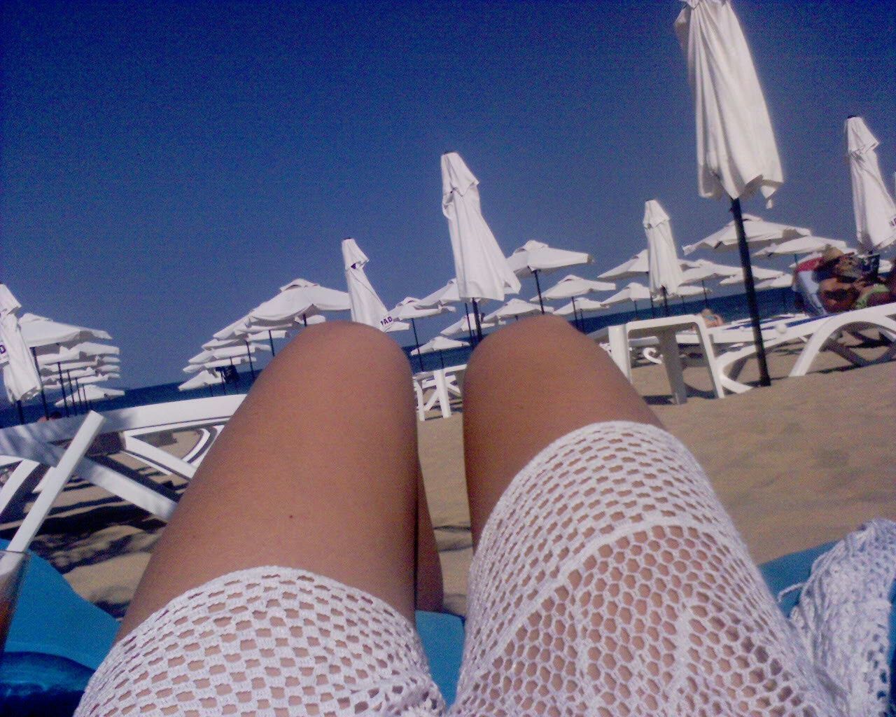 Midsection of woman relaxing on chair at beach