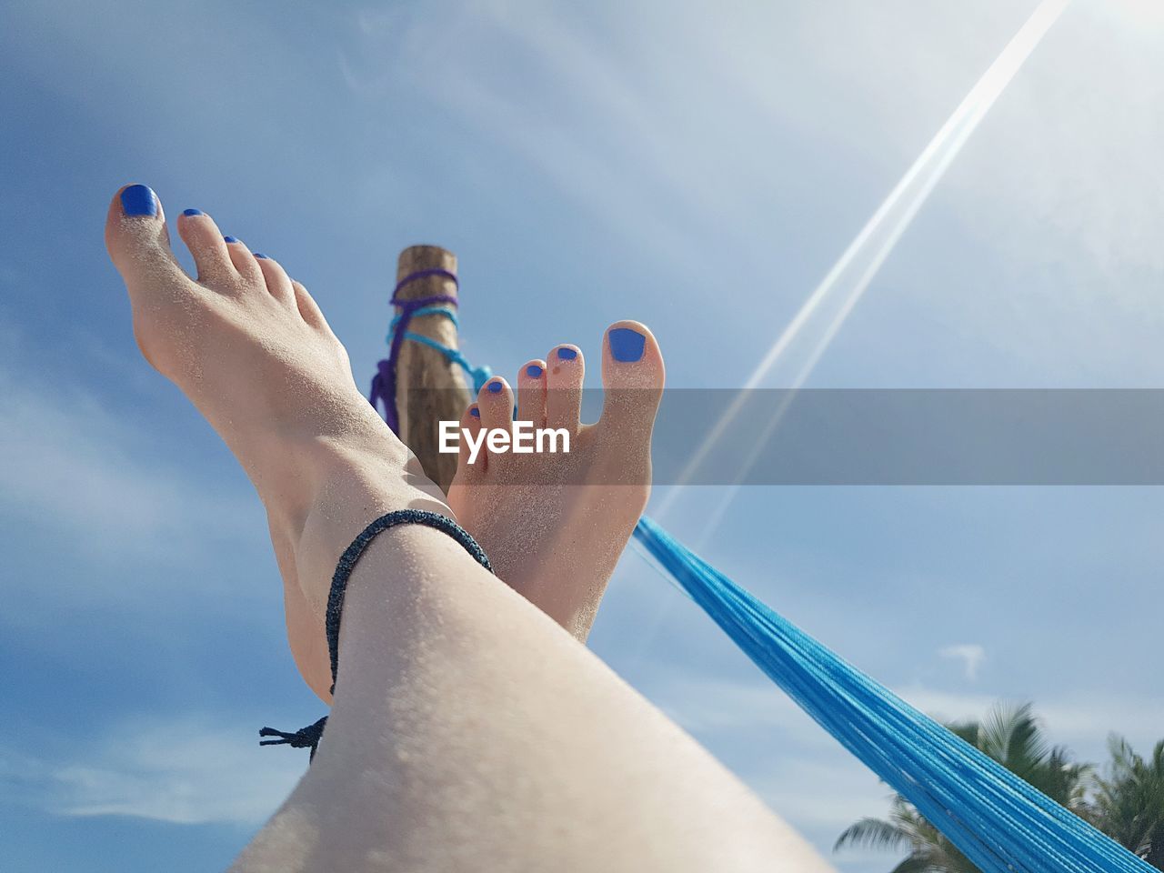 Low section of woman with feet up against sky