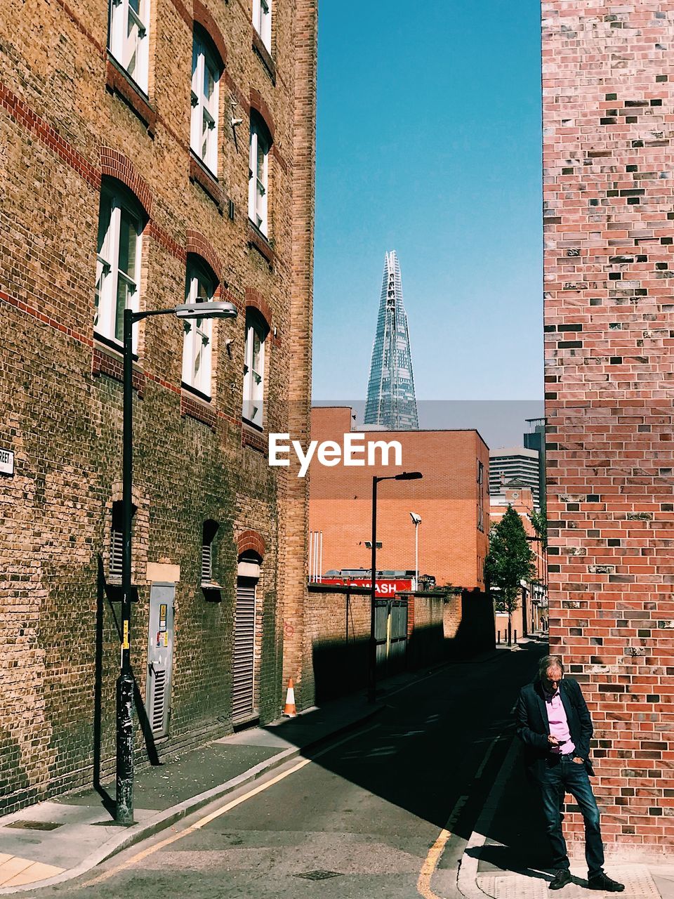 STREET BY BUILDINGS AGAINST SKY