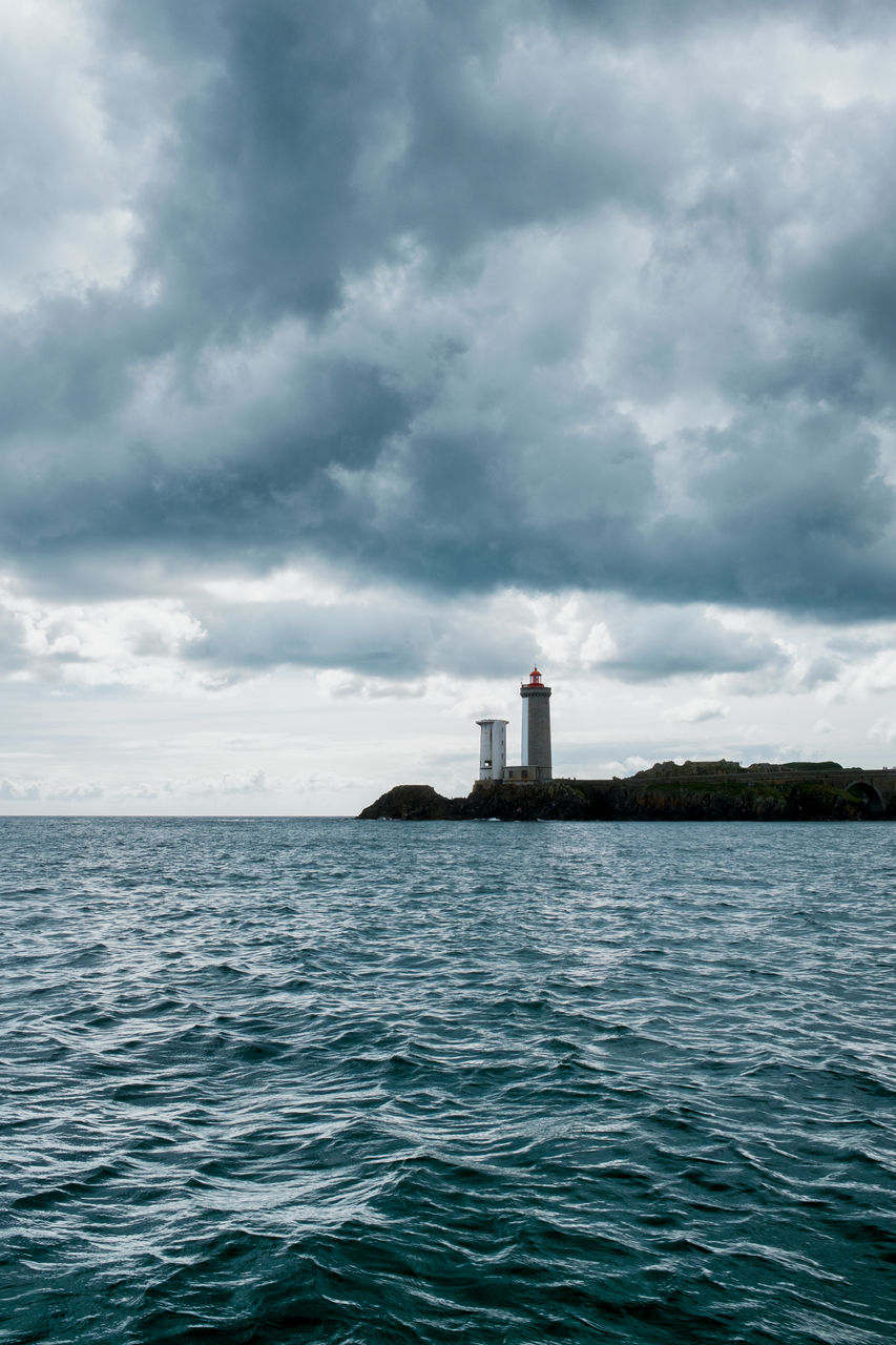 Lighthouse by sea against sky