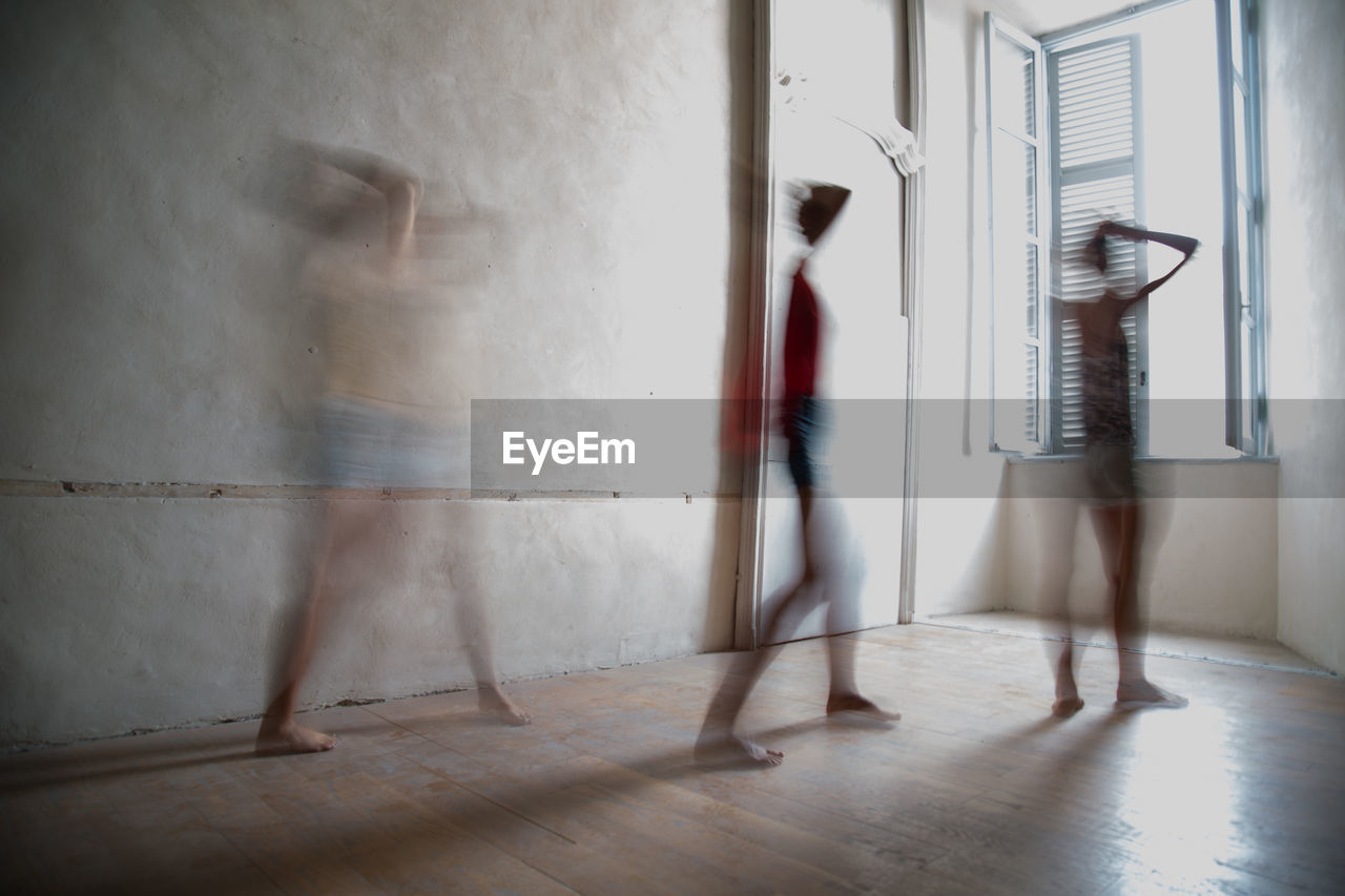 BLURRED MOTION OF MAN WALKING IN CORRIDOR