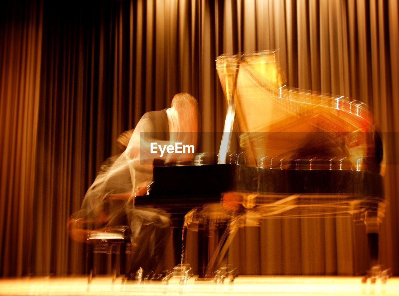 Blur image of musician playing piano on stage