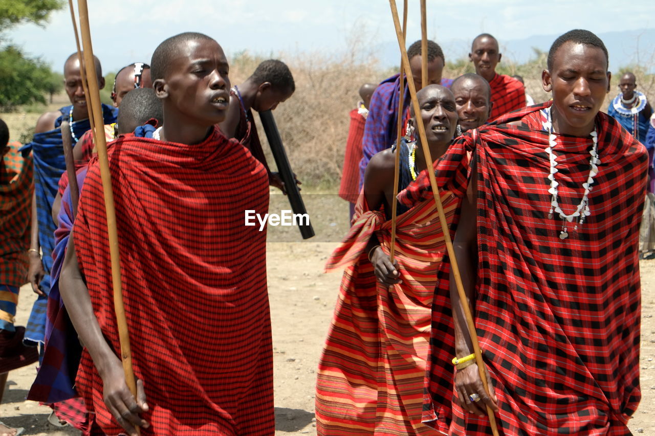 GROUP OF PEOPLE LOOKING AT TRADITIONAL CLOTHING