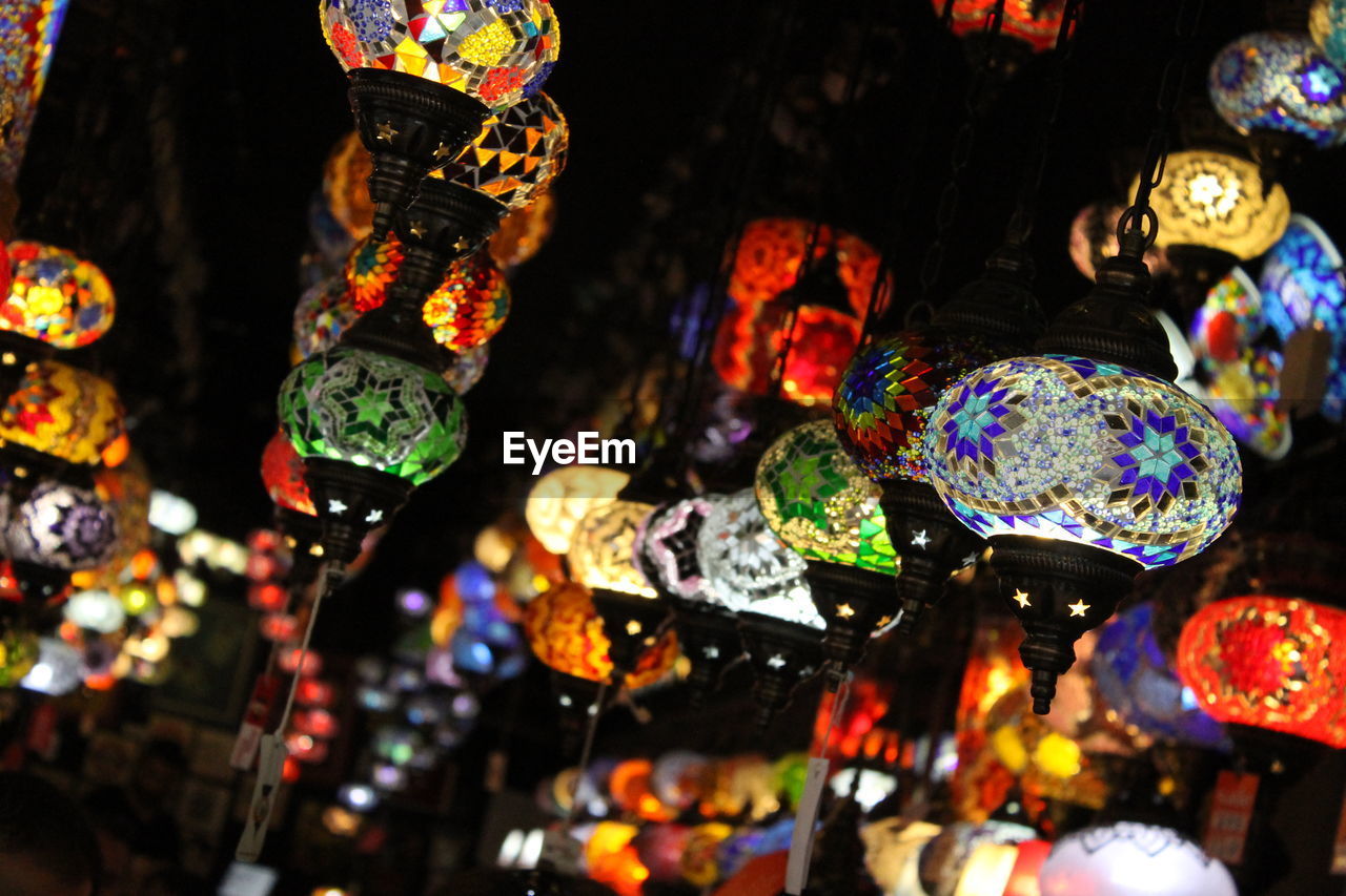 Close-up of illuminated lanterns hanging at market stall